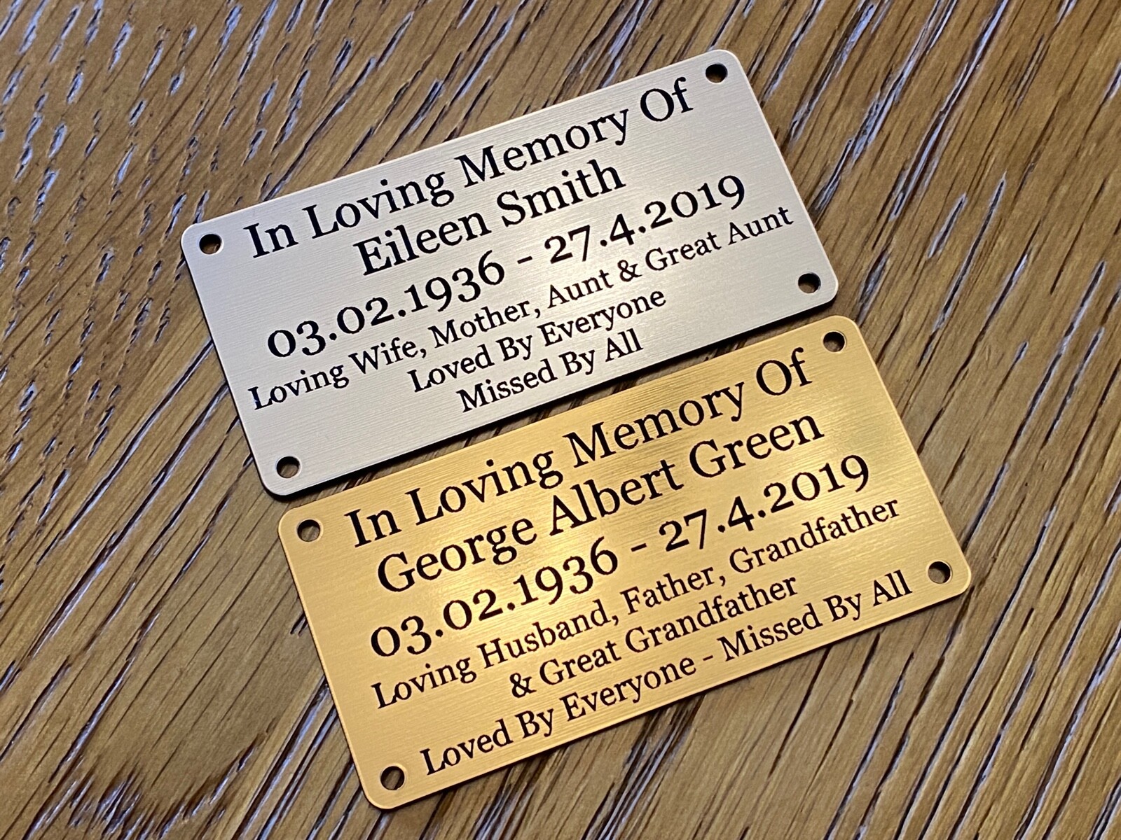 Silver and gold memorial plaques shown on wood