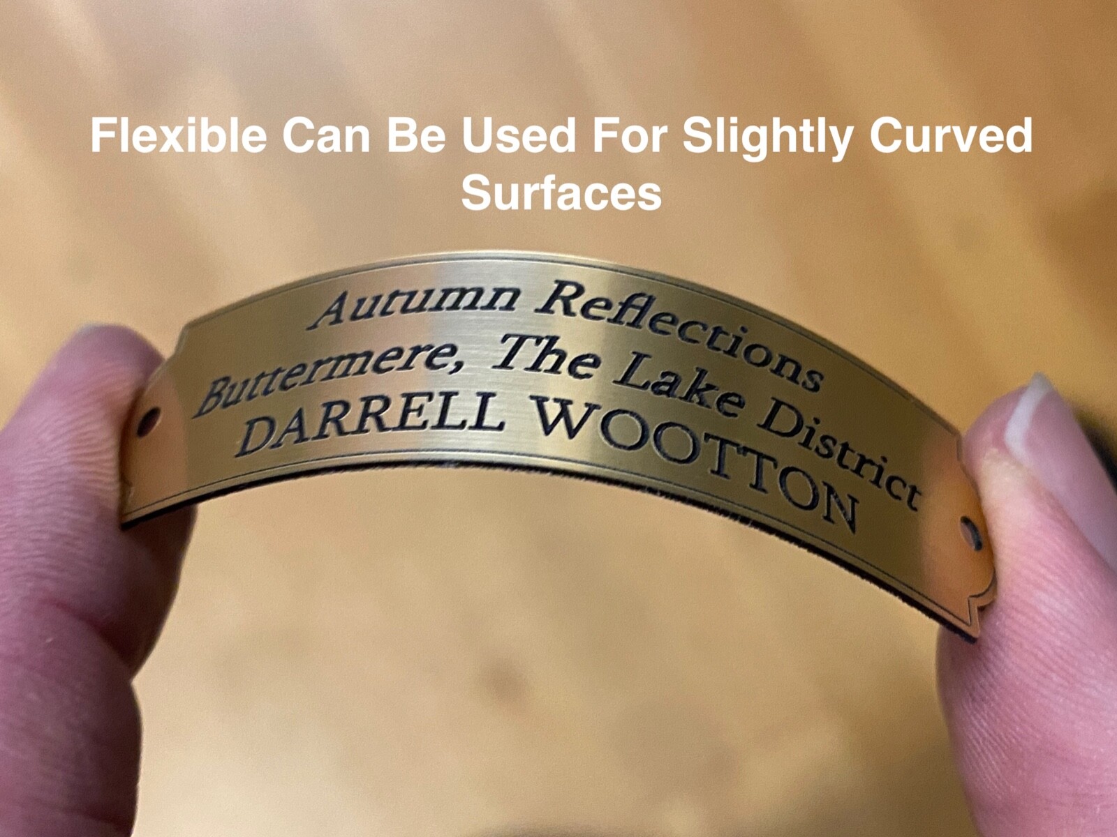 Thin flexible plaque being gently curved to show it bends